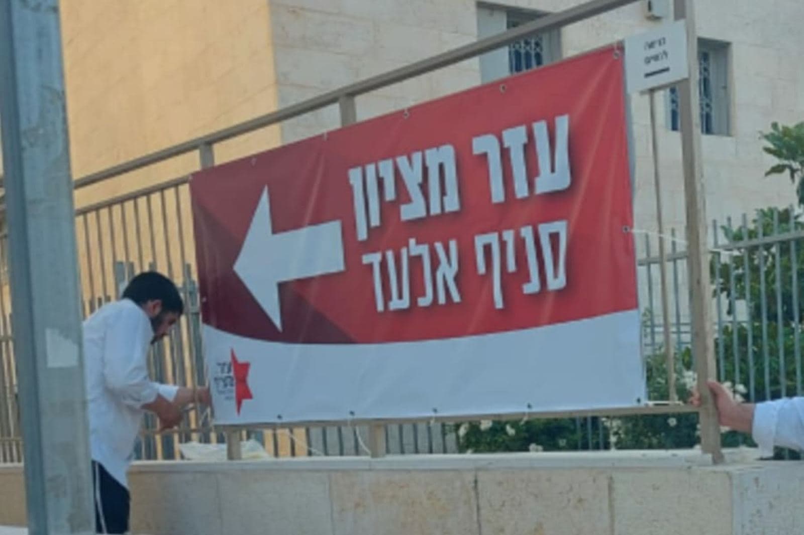תליית שלט בד על גדר