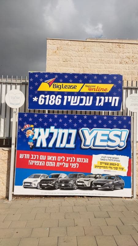 שלט חוצות על גדר בשכונה