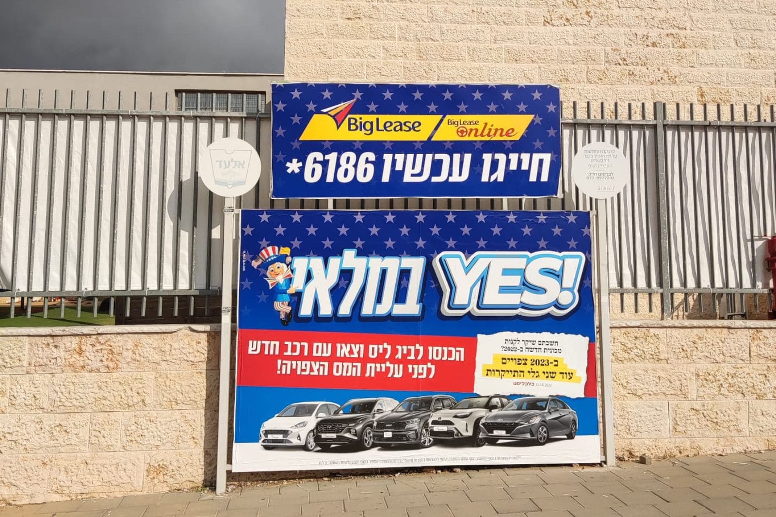 שלט חוצות גדול על גדר ברחוב