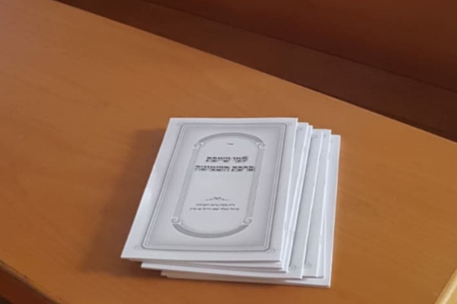 עלונים מונחים על שולחן בבית הכנסת