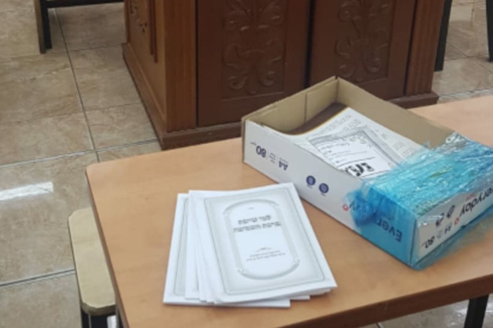 עלוני שבת מונחים על שולחן בבית הכנסת